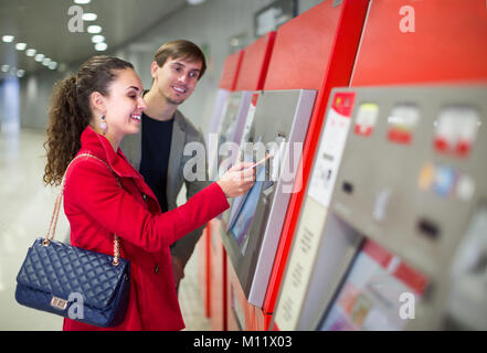 Allegro i giovani passeggeri acquistando il biglietto della metropolitana in corrispondenza del terminale. Focus sulla donna Foto Stock