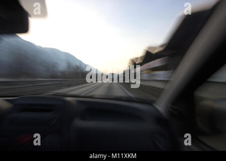 Automobile che viaggia in montagna con camion avanti shot dal sedile passeggeri all'interno dell'auto Foto Stock