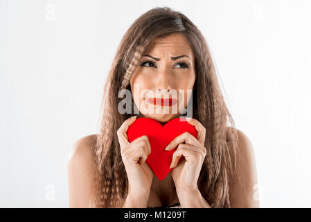 Bella ragazza infelice piangendo e azienda rotto cuore rosso. Il giorno di San Valentino del concetto. Foto Stock