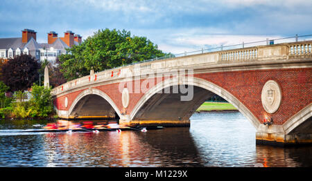 Università di Harvard team sculling mattina presto pratica. Battello passa sotto un ponte sul fiume Charles e a Cambridge, Massachusetts. Motion Blur. Foto Stock