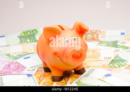 Rosa piggybank con le banconote in euro Foto Stock