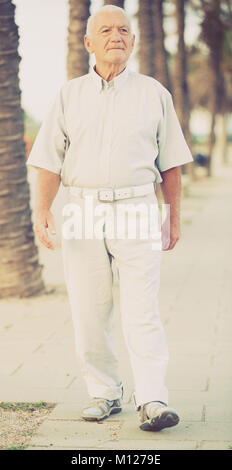 Anziano pensionato maschio nella camicia di andare per strada in vacanza Foto Stock