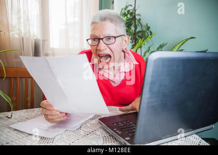 Senior donna oltraggiate con fatture di società di elettricità Foto Stock