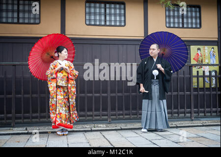 25.12.2017, Kyoto, Giappone, Asia - una giovane coppia che indossa gli abiti tradizionali comporta per un ritratto nella vecchia città di Kyoto. Foto Stock