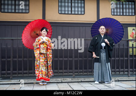 25.12.2017, Kyoto, Giappone, Asia - una giovane coppia che indossa gli abiti tradizionali comporta per un ritratto nella vecchia città di Kyoto. Foto Stock