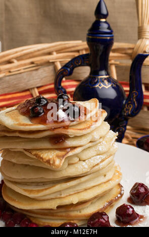 Piccoli pancake e bacche blu con tè pentola Foto Stock