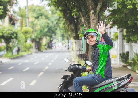 Ritratto di felice uomo asiatico il lavoro come un motociclo commerciale conducente Foto Stock