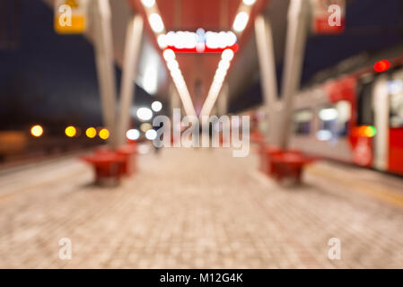 Immagine sfocata dei treni ad alta velocità dalla piattaforma della stazione in serata. Foto Stock