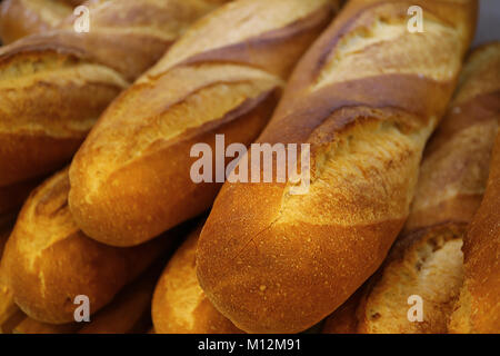 Chiuso fino pila di fatta fresca baguette francese pane, con messa a fuoco selettiva e sfondo sfocato Foto Stock