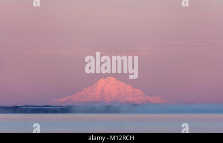 Nebbia in rotoli sul lago Skilak nel Kenai National Wildlife Refuge come sunrise bagna Mount Redoubt con alpenglow centromeridionale in Alaska. Foto Stock