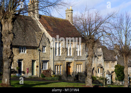 Freddo inverno il sole sulle pittoresche case che la linea per la collina a Burford, Cotswolds, Oxfordshire, England, Regno Unito Foto Stock