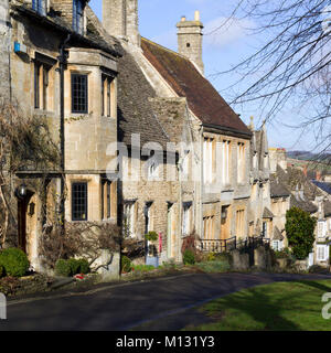 Freddo inverno il sole sulle pittoresche case che la linea per la collina a Burford, Cotswolds, Oxfordshire, England, Regno Unito Foto Stock