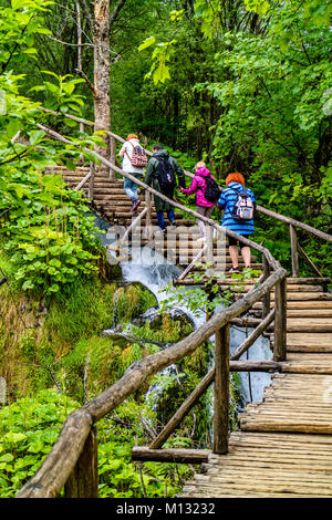 I turisti a piedi fino boardwalk passi al Parco Nazionale dei Laghi di Plitvice, Croazia Foto Stock
