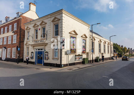 Una donna guarda al poster sulla parete di Beccles pubblico e sala teatro, Beccles, Suffolk, Regno Unito Foto Stock