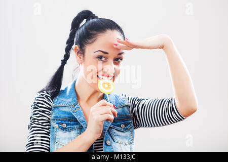 Felice ragazza con lollipop salutando Foto Stock