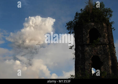 Mt. Mayon eruttate (arcobaleno su lato sinistro) nella mattina in anticipo con la cenere vulcanica cade dal punto di vista di Cagsawa Parco Nazionale in Daraga, Albay, Bicol a gennaio 26, 2018. L'Istituto filippino di vulcanologia e sismologia (PHILVOLCS) dichiarati numero di avviso 8 e una più ampia della zona di pericolo a 8 chilometri dopo le esplosioni la continua attività attive del vulcano di questo passato diversi giorni. Secondo i rapporti è un totale di 74.000 persone sono colpite e 100 milioni di euro di danni nei terreni agricoli secondo del dipartimento dell'Agricoltura (DAR) (foto da Gregorio B. Dantes Jr./P Foto Stock