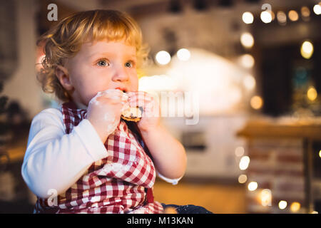 Il Toddler boy rendendo gingerbread cookies a casa. Foto Stock