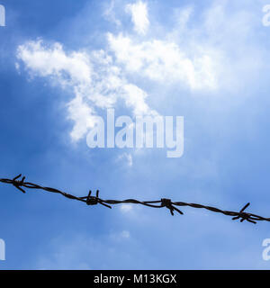 Filo spinato sul recinto con cielo blu di sentirsi preoccupante Foto Stock