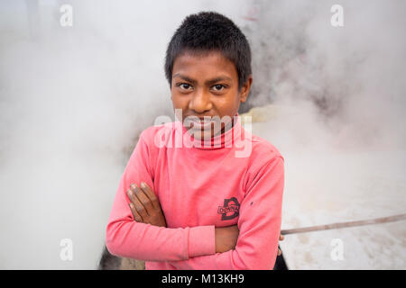 Operaio bengalese Babu, 12, bolle di sap della data Palm tree per preparare Jiggery. Foto Stock