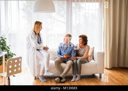 Medico donna parlando a una coppia senior. Foto Stock