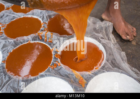 Bollito Data calda Palm Tree succo di frutta viene versato nel contenitore in corrispondenza Iswardi, Bangladesh. Foto Stock