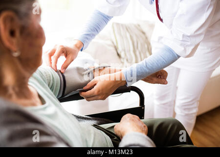 Salute e visitatori un senior donna durante la visita iniziale Foto Stock