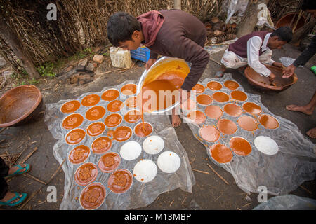 Bollito Data calda Palm Tree succo di frutta viene versato nel contenitore in corrispondenza Iswardi, Bangladesh. Foto Stock