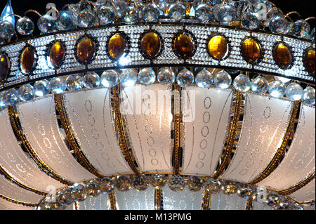 Close-up di splendido lampadario di cristallo la forma rotonda che pendevano dal soffitto all'interno. Foto Stock