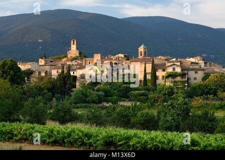 Francia, Vaucluse, Parc Naturel Regional du Luberon (Parco naturale regionale del Luberon), Lourmarin, etichettati Les Plus Beaux Villages de France (i più bei villaggi di Francia), la torre dell orologio e il campanile della chiesa, il massiccio del Luberon in background Foto Stock