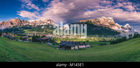 Cortina d'Ampezzo città vista panoramica con alpine paesaggio verde e imponenti Dolomiti Alpi in background. Provincia di Belluno, Alto Adige, Ital Foto Stock