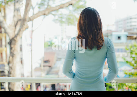 Bella ragazza asiatica godendo la freschezza sul balcone Foto Stock