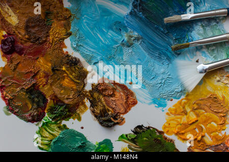 Close-up di artista pennelli e vernici colorate su una tavolozza di colore bianco Foto Stock