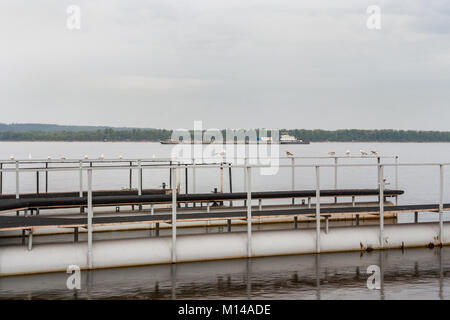 Piattaforma di metallo per l'attracco delle barche e grandi barcone sul fiume Volga. Foto Stock