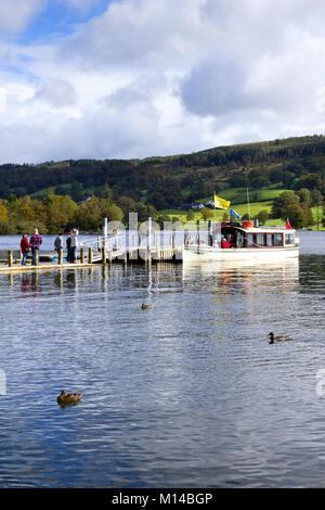 Coniston, Regno Unito - 14th settembre 2011: Una crociera turistica in barca aspetta al sole di inizio autunno per i passeggeri a bordo da un molo vicino al villaggio di Coniston sull'acqua Coniston nel Parco Nazionale del Distretto del Lago, Cumbria, Regno Unito. Coniston Water è il terzo lago più grande dell'English Lake District. Foto Stock