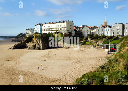 Tenby, Regno Unito - 7th novembre 2011: Una coppia a piedi fuori a novembre sole su una spiaggia vuota del castello a Tenby, Pembrokeshire, Galles, Regno Unito. Tenby sperimenta un clima marittimo con estati fresche e inverni miti ed è uno dei luoghi più soleggiato del Galles. Foto Stock