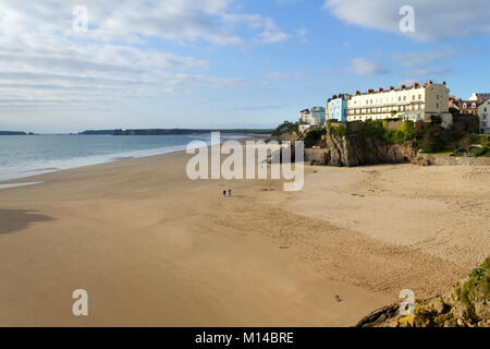 Tenby, Regno Unito - 7th novembre 2011: Una coppia a piedi fuori a novembre sole su una spiaggia vuota del castello a Tenby, Pembrokeshire, Galles, Regno Unito. Tenby sperimenta un clima marittimo con estati fresche e inverni miti ed è uno dei luoghi più soleggiato del Galles. Foto Stock