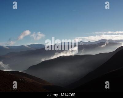 Inverno mattina le nebbie che salgono dal nelle vallate del Parco Nazionale del Distretto dei Laghi, Cumbria, Regno Unito Foto Stock