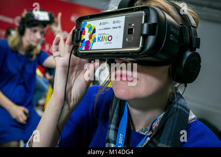 Una ragazza in marcia occhiali VR con entusiasmo la visione di un filmato nella cuffia di realtà virtuale nel cinema in città Sochi, Russia Foto Stock