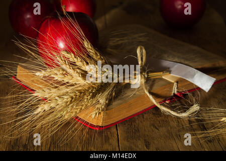 Le mele rosse e spighe di grano sul libro aperto Foto Stock