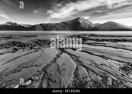 I canali nel limo del braccio Turnagain creato dalla bassa marea con le Kenai Mountains sullo sfondo vicino a Portage centromeridionale in Alaska. Foto Stock