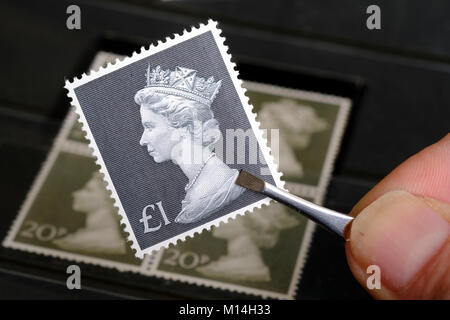 Vintage £1 timbro essendo trattenuto dal collettore di timbro Foto Stock