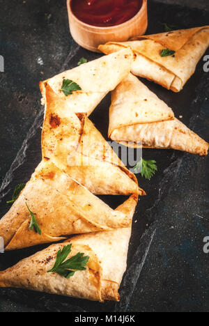 Cibo asiatico. Vegetariano (samsa samosa) con salsa di pomodoro. Sfondo blu scuro spazio copia Foto Stock