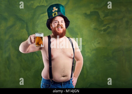 Un uomo grasso con una barba a san Patrizio tuta è sorridente con un m Foto Stock