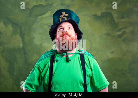 Un uomo grasso con una barba a san Patrizio tuta è sorridente. Foto Stock