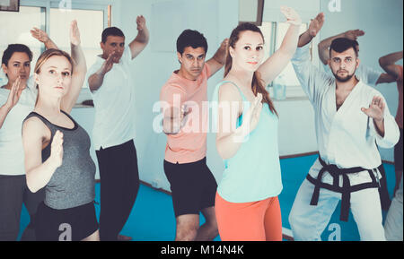 Giovani adulti spagnolo di tentare di nuovo master si sposta durante il karate class Foto Stock