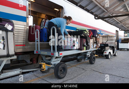 Amtrak porter carico dei bagagli nel bagaglio auto presso una stazione a Tampa, in Florida. Foto Stock