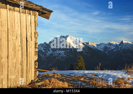 Capanna in legno al tramonto sopra la Valle del Lech con vista della Lechtal Alpi. Tirolo, Austria Foto Stock