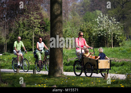 I Paesi Bassi, 's-Graveland. Madre e 2 bambini in atto in bicicletta. Foto Stock