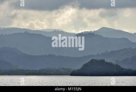 Twilight prima del sorgere del sole sulla costa dell'oceano. Oceano e Montagne Paesaggio presso la mattinata nebbiosa. Isola di Komodo. Molucche, indonesiane Molucche, Spice Isla Foto Stock