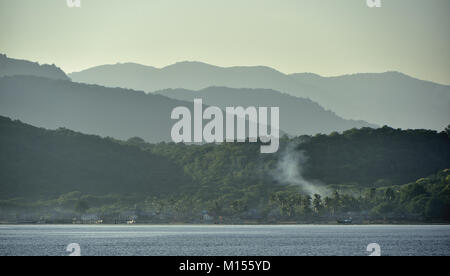 Twilight prima del sorgere del sole sulla costa dell'oceano. Oceano e Montagne Paesaggio presso la mattinata nebbiosa. Isola di Komodo. Molucche, indonesiane Molucche, Spice Isla Foto Stock